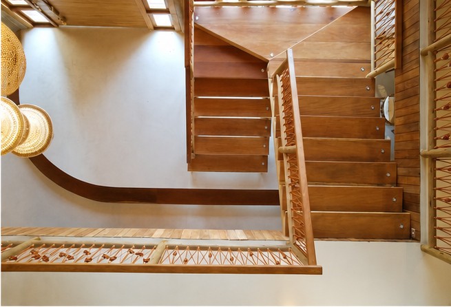 Escalier en bois massif et suspensions en fibre tressée dans le patio de la villa